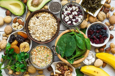 gesunde Lebensmittel wie Avocados, Nüsse, Haferflocken, Bohnen und Spinat.