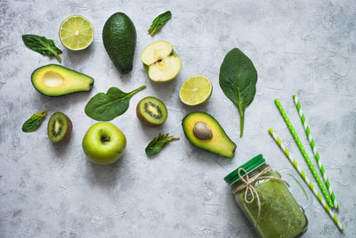 grüne Avocado mit grünen Früchten auf dem Boden