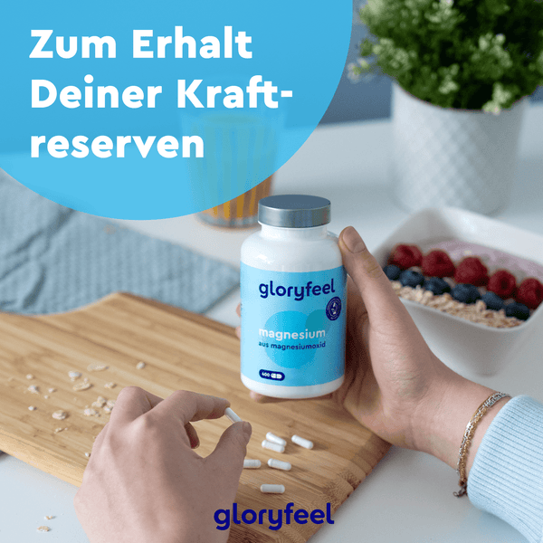 Eine Person an einem Tisch schüttet Kapseln aus einer Magnesiumoxid-Kapseln-Flasche der Gloryfeel GmbH auf ein Holztablett, daneben Obst. Text: „Zum Erhalt Deiner Kraftreserven“.