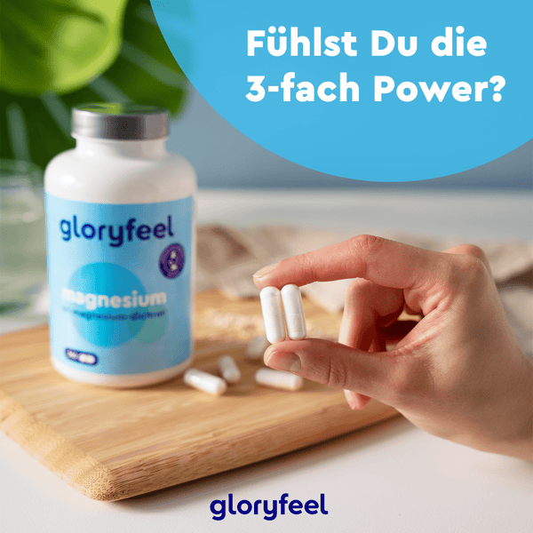A hand holds capsules next to a bottle of Tri-Magnesium Dicitrat + MSM on a wooden board, with the text "Fühlst Du die 3-fach Power?" in the background.