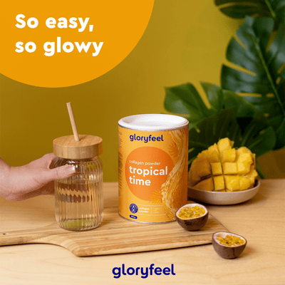 Auf einer Holztafel ist das Kollagen Pulver Tropical Time der gloryfeel GmbH abgebildet, dazu gibt es Mangoscheiben und ein Glas mit Strohhalm. Text: „So easy, so glowy mit Coenzym Q10.“.