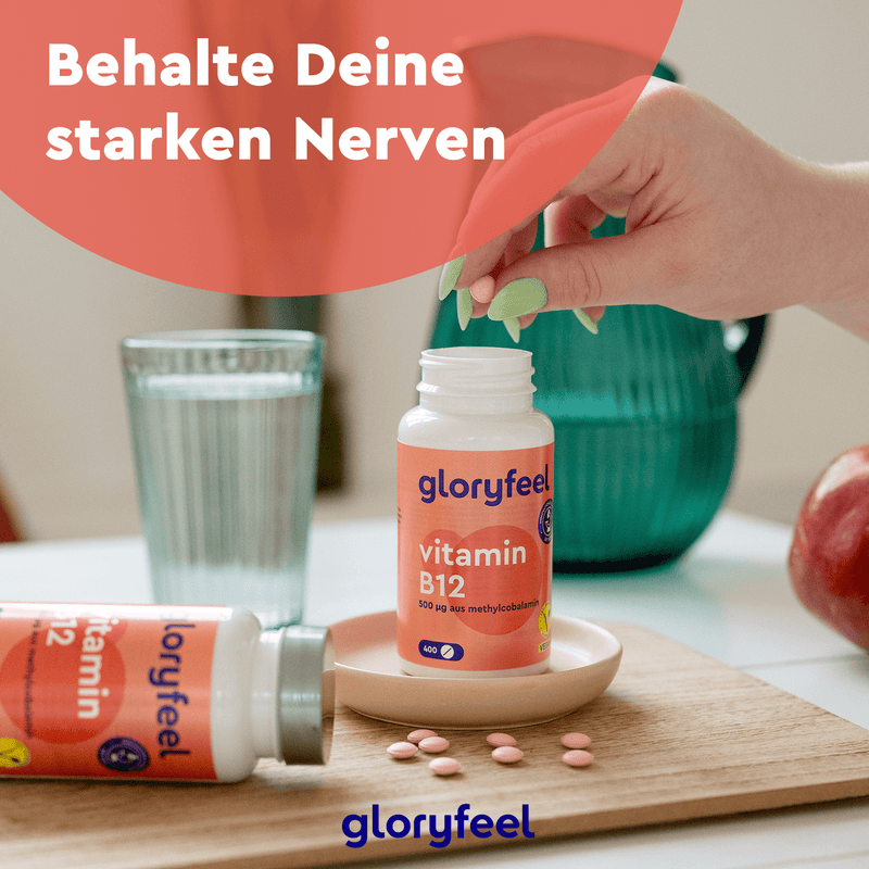 Eine Person nimmt eine Tablette aus einer Flasche mit Vitamin B12-Methylcobalamin-Tabletten der gloryfeel GmbH auf einem Tisch mit einer weiteren Flasche, einem Wasserglas und einem Apfel. Der deutsche Text hebt die Premium-Qualität dieser Nahrungsergänzungsmittel hervor.