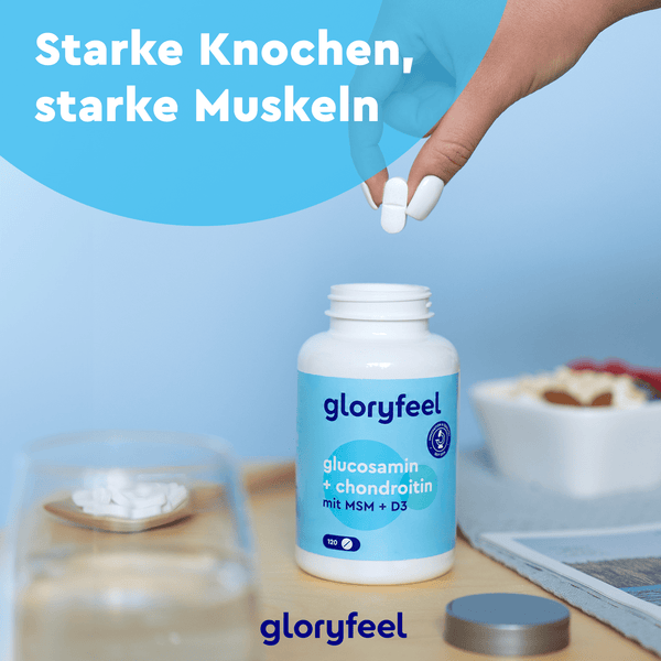 Eine Hand hält eine weiße Pille über einer Flasche mit der Aufschrift „Glucosamin + Chondroitin + MSM Tabletten“ der gloryfeel GmbH auf einem Tisch mit Essen und Getränken. Der Text lautet „Starke Knochen, starke Muskeln“ und hebt die Vorteile von Glucosamin und Vitamin D3 für starke Knochen und Muskeln hervor.