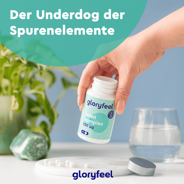 Vorsichtiges Ausschütten von Tabletten aus einer „Selen Tabletten“-Flasche der gloryfeel GmbH auf einen Tisch vor dem Hintergrund einer Pflanze und eines Steins. Deutscher Text: „Der Underdog der Spurenelemente.“.