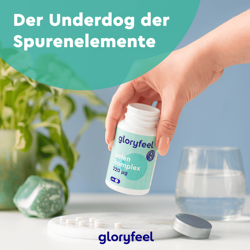 Vorsichtiges Ausschütten von Tabletten aus einer „Selen Tabletten“-Flasche der gloryfeel GmbH auf einen Tisch vor dem Hintergrund einer Pflanze und eines Steins. Deutscher Text: „Der Underdog der Spurenelemente.“.