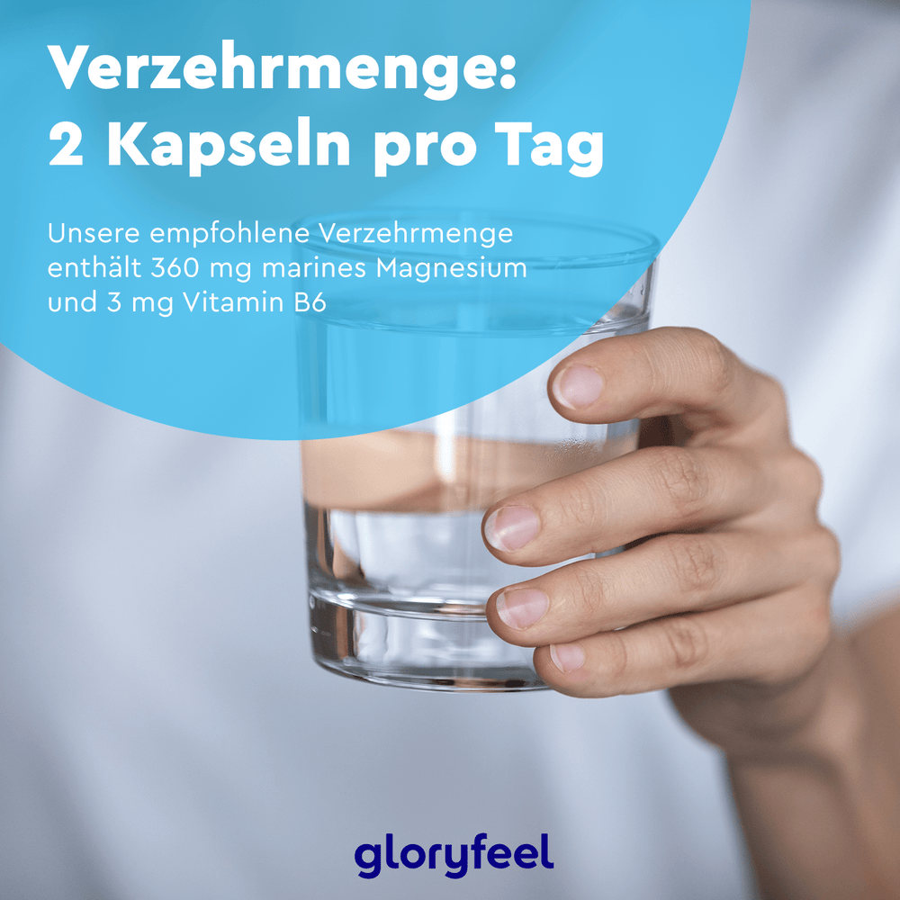 Eine Person hält ein Glas Wasser, um die tägliche Einnahme von zwei Marines Magnesium Kapseln der gloryfeel GmbH hervorzuheben, die jeweils Magnesium und Vitamin B6 zur Unterstützung einer optimalen Muskelfunktion enthalten.