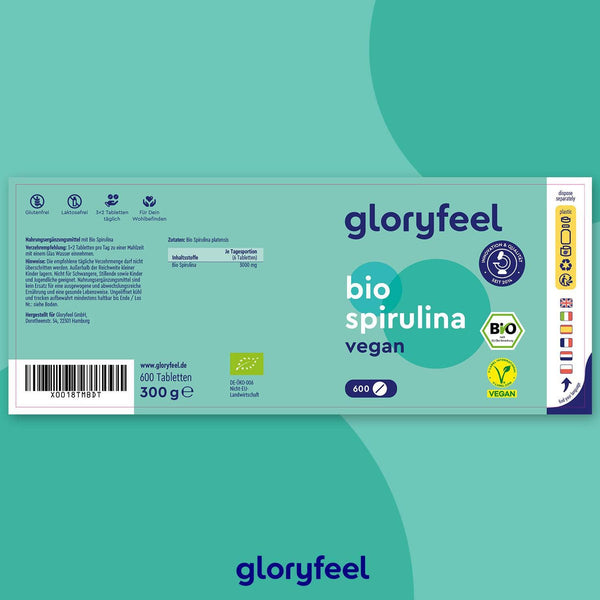 Grün-blaue Verpackung für die Bio Spirulina Tabletten der gloryfeel GmbH, mit Vitamin B12, 600 Tabletten à 300 g. Inklusive Produktzertifikaten und detaillierten Nährwertangaben in deutscher Sprache.