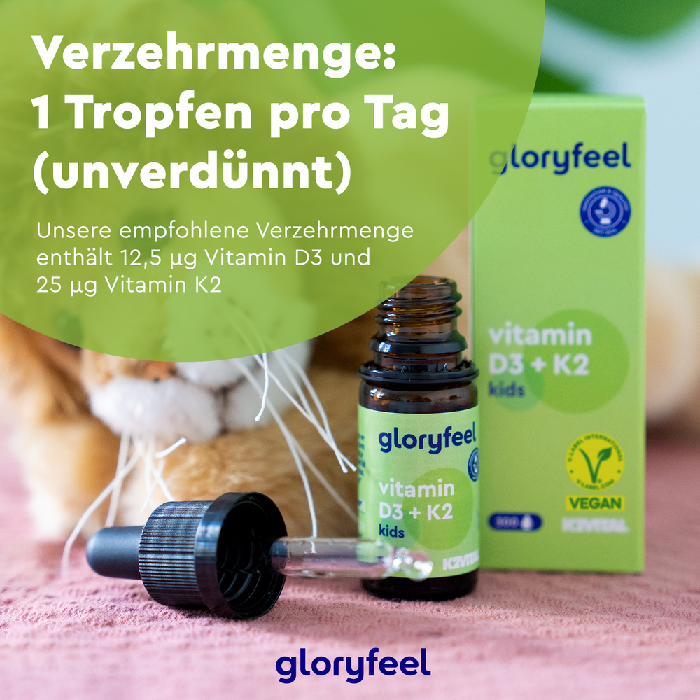 Die Vitamin D3 K2 Kids Tropfen der gloryfeel GmbH stehen in einer Tropfflasche auf dem Tisch, ihre Verpackung betont die Dosierung, ist vegan und enthält MK-7 für eine optimale Aufnahme.